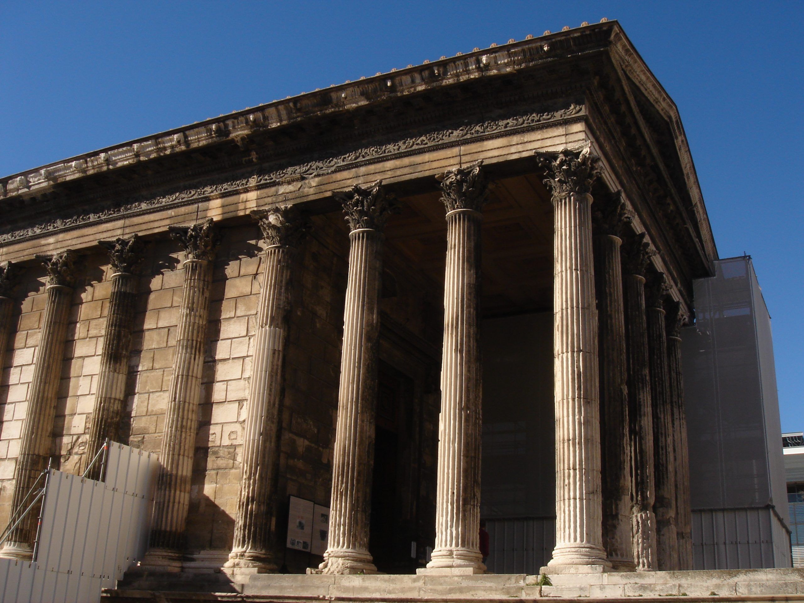 Side view of the Maison Carrée temple in Nîmes with scaffolding on both sides.