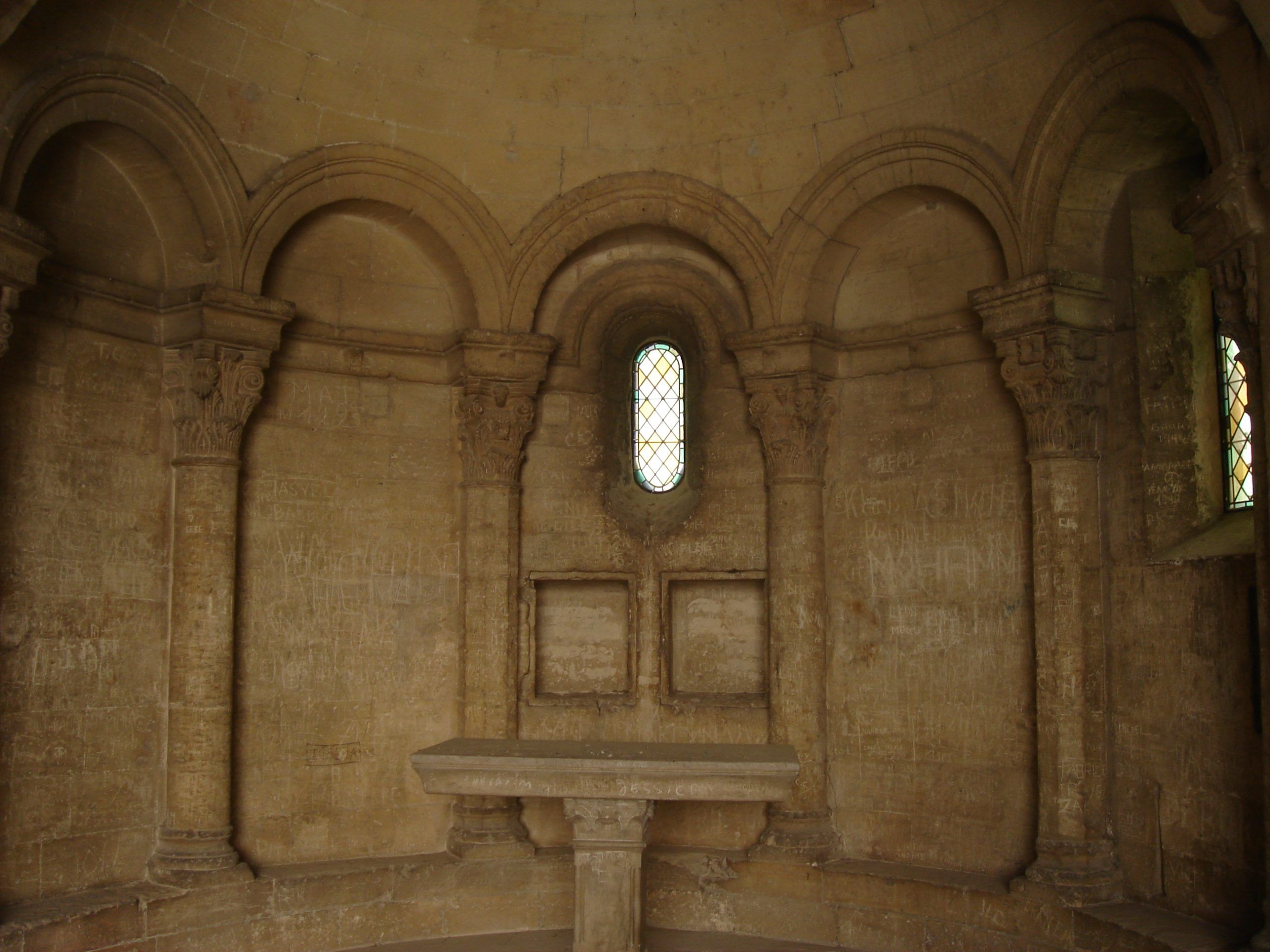 Interior of a small chapel inside the Papal Palace at Avignon, with stone columns and stained glass windows.