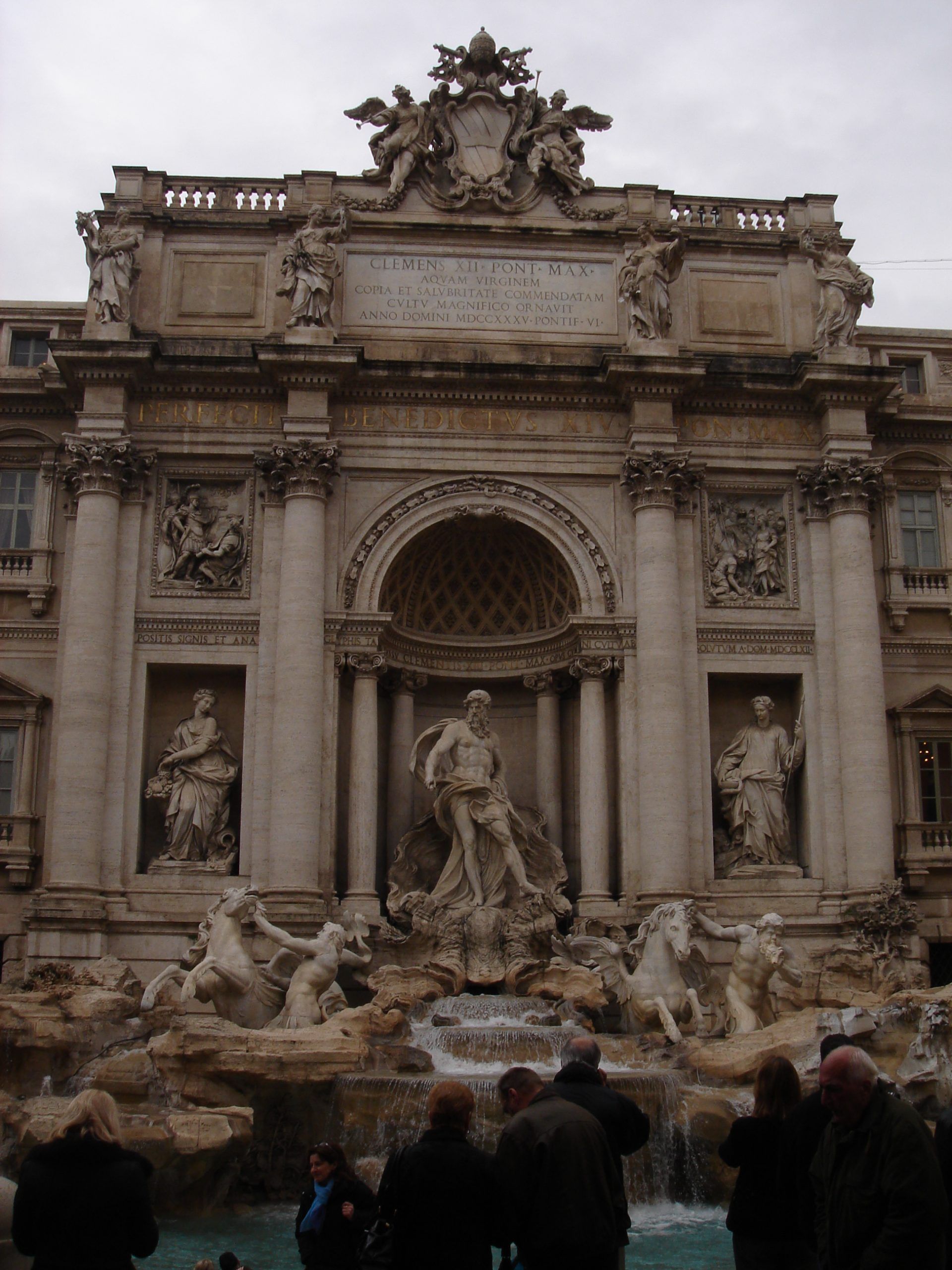 The Trevi Fountain in Rome, with dramatic Baroque sculptures and cascading water surrounded by tourists.