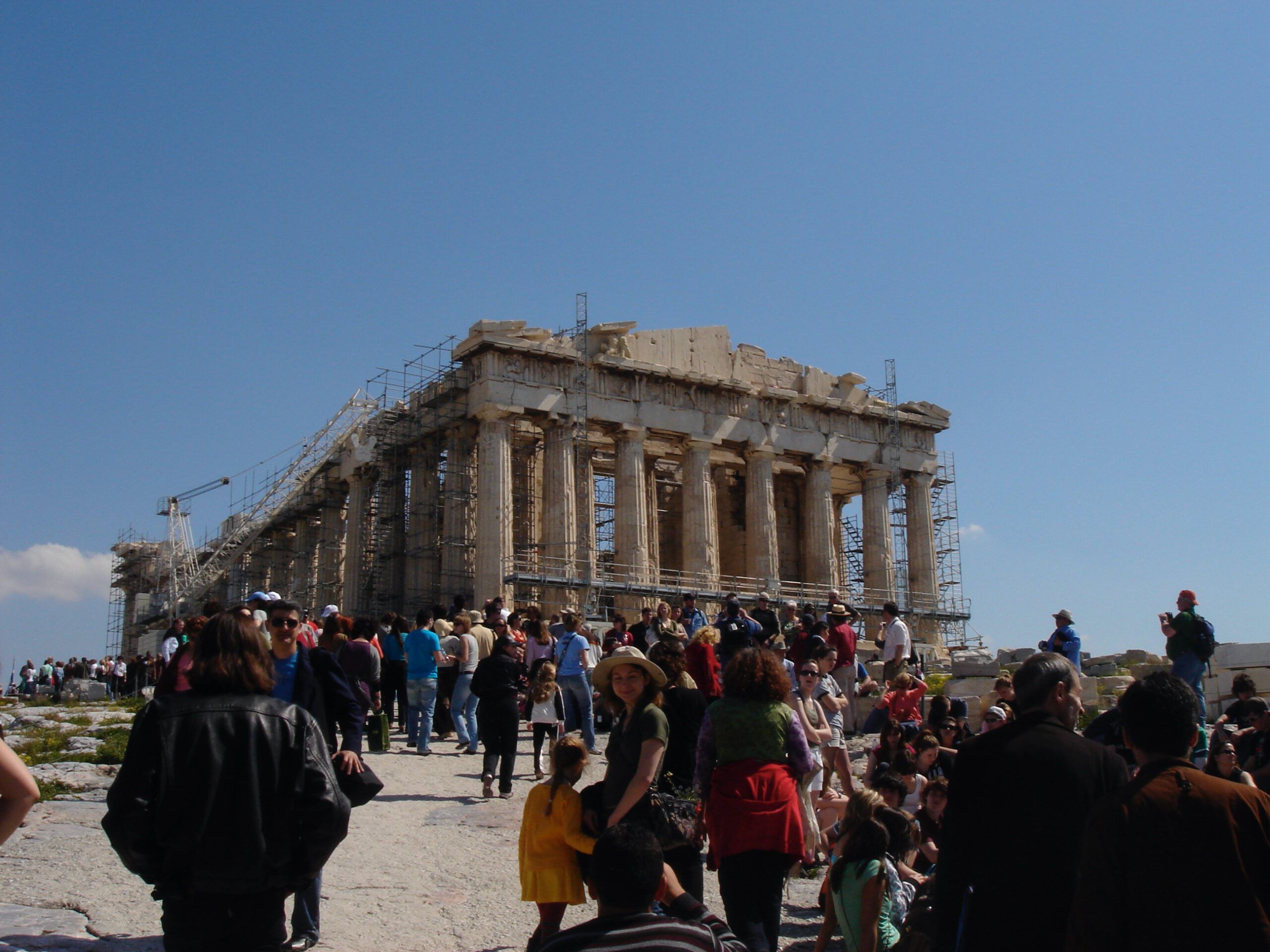 The Propylaia on the Acropolis, with a large crowd of tourists ascending the steps toward its ancient gateway.