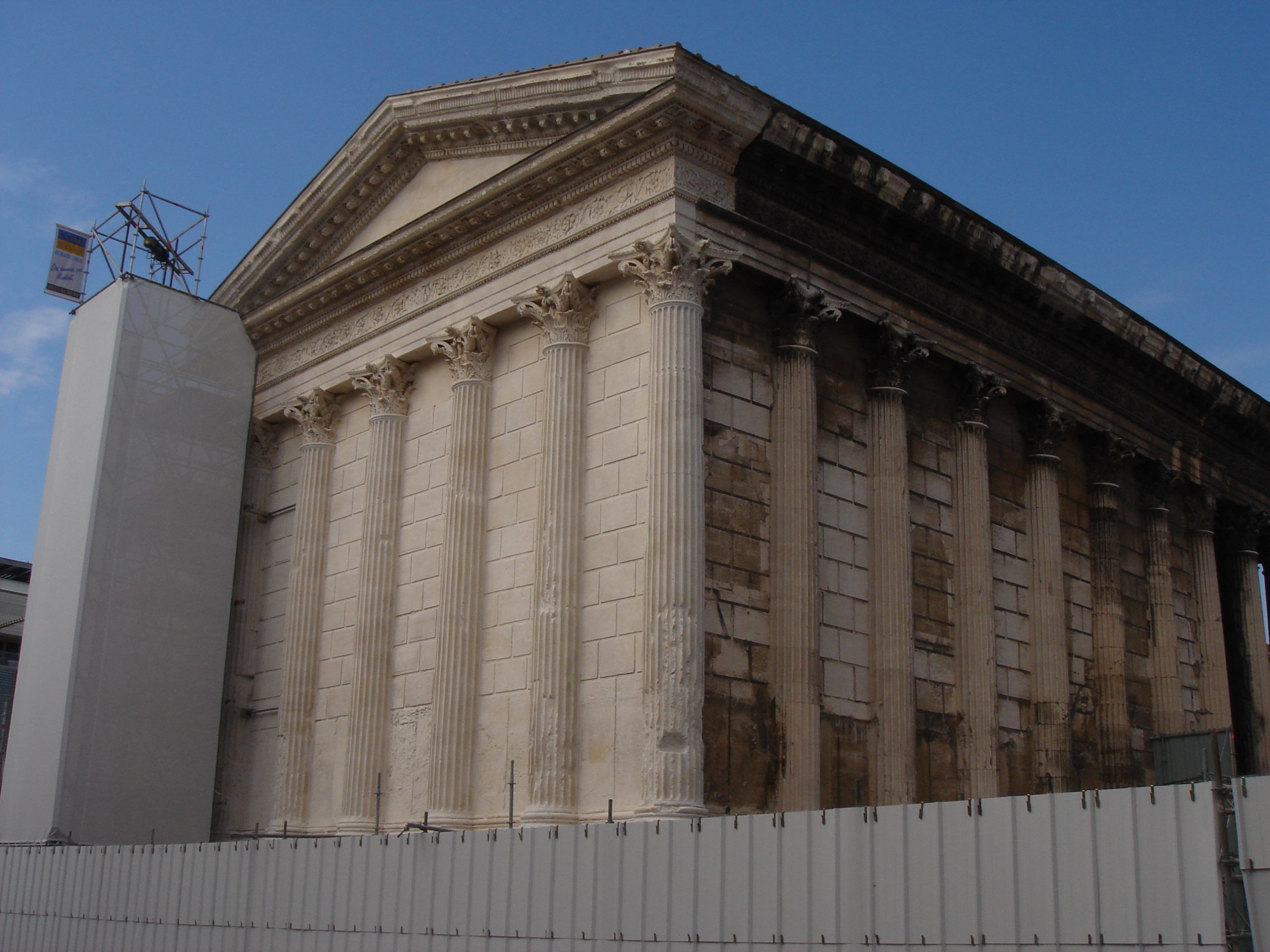 The Maison Carrée in Nîmes, a well-preserved Roman temple with Corinthian columns, undergoing partial restoration.