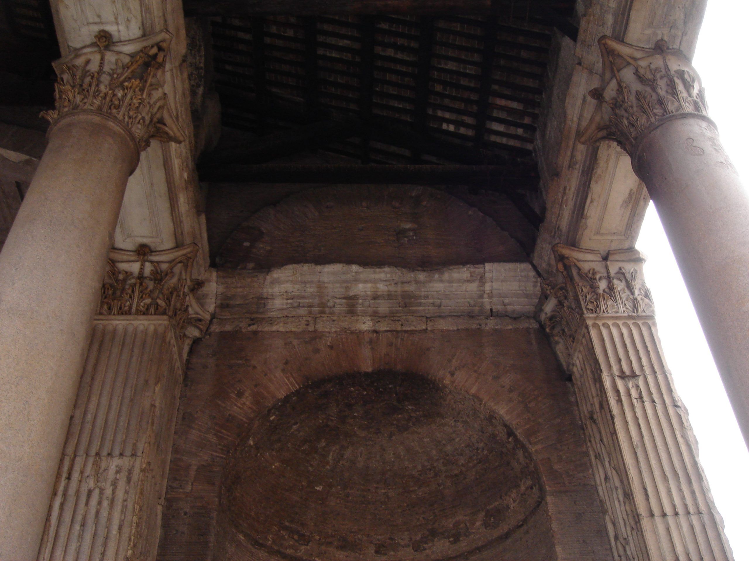 View looking up at the coffered ceiling of the Pantheon portico, with Corinthian columns and brick vaulting.