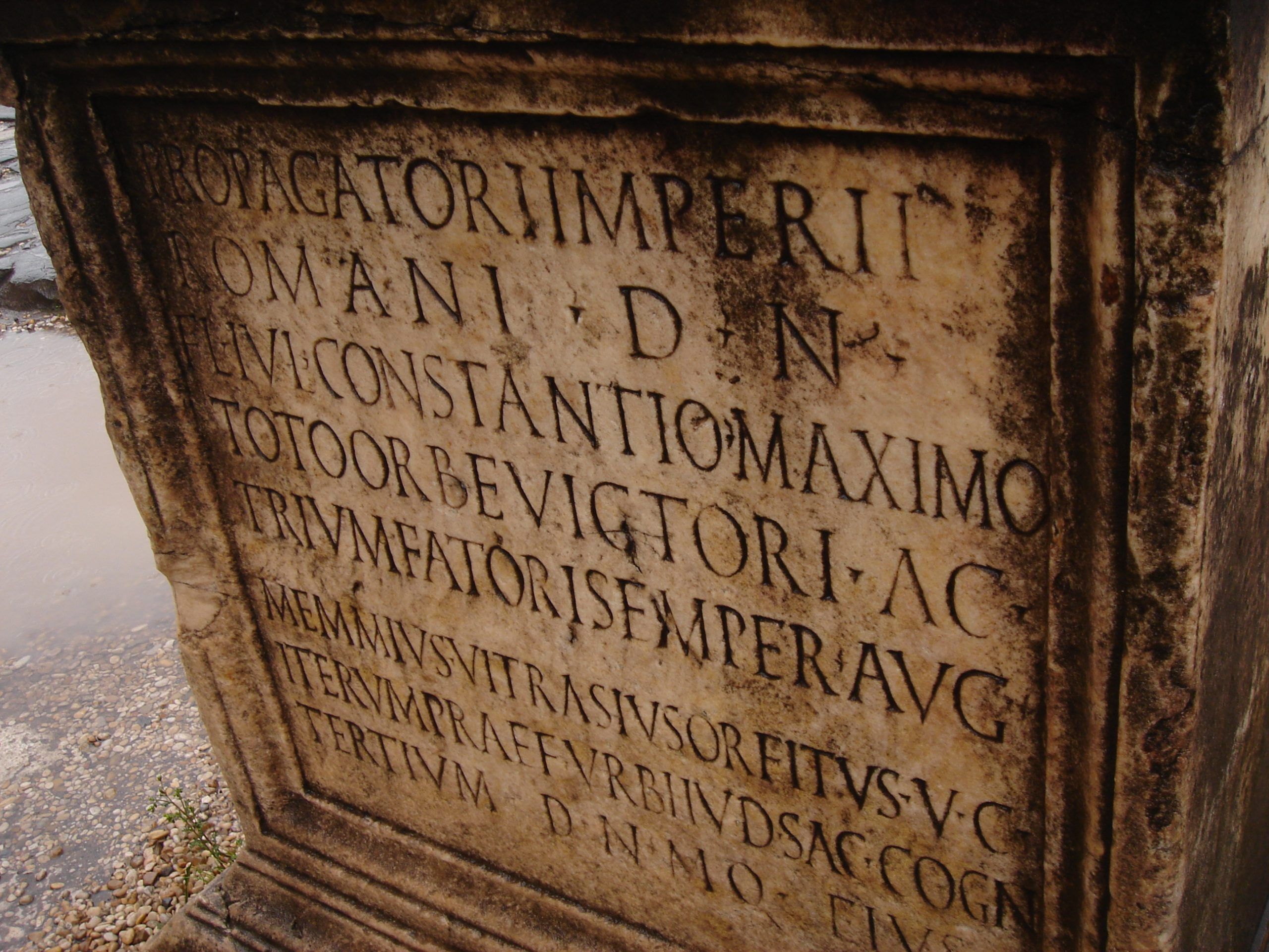 Close-up of a Latin inscription carved into a marble plinth, commemorating Emperor Constantine’s victories.