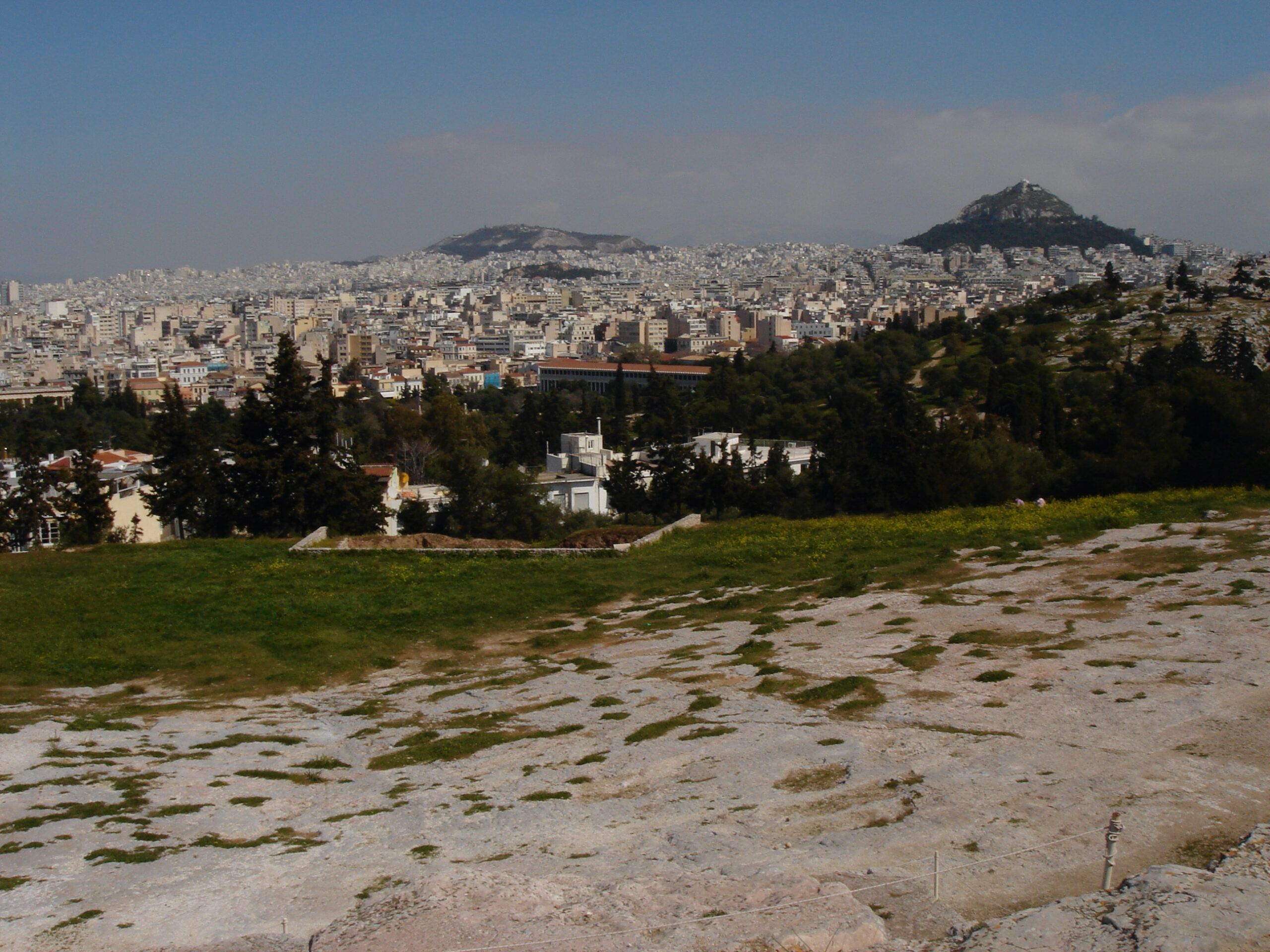 View from the Propylaia entrance of the Acropolis looking out toward Athens, with marble columns framing the foreground.