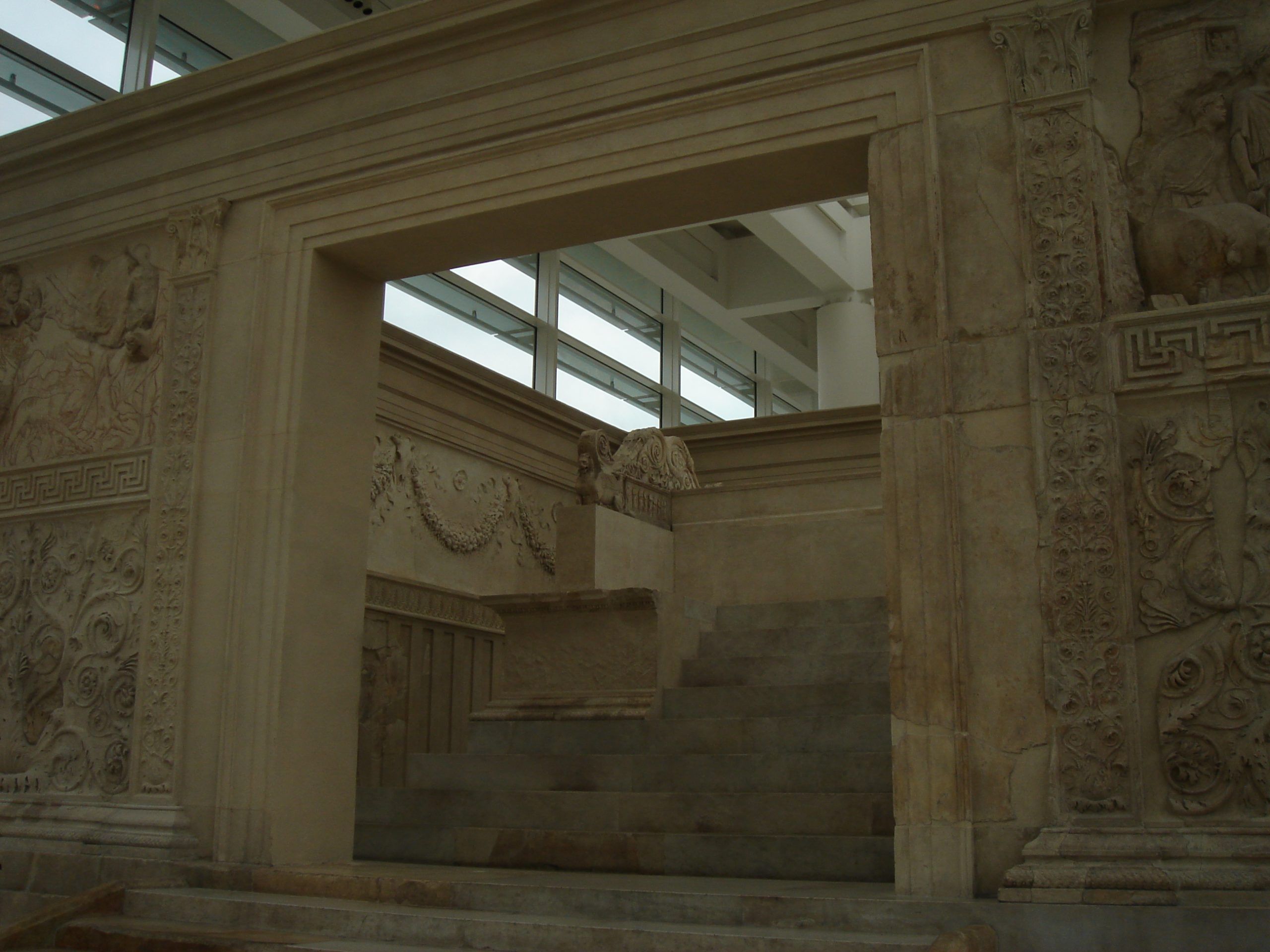 Close-up of the entrance to the Ara Pacis Augustae, showing detailed floral friezes, decorative panels, and the interior altar steps.